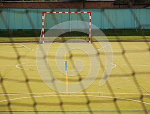 Empty handball gate. Outdoor football or handball playground, plastic light green surface on ground