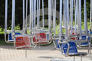 Empty hanging seats for children on the carousel