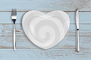 Empty heart plate top view on blue wood table