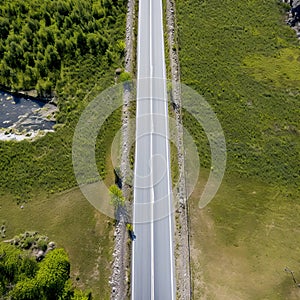 An empty highway is captured from a top-down perspective, offering an aerial view of the great landscape it traverses