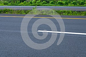 Empty highway with dividing line, roadside and green grass