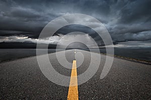 Empty highway leading to the mountains through the rain.