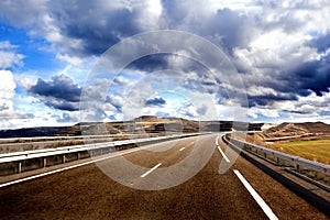 Empty highway,mountain landscape and cloudy sky.Road and car travel concept