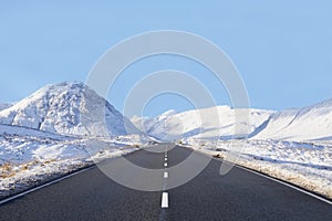 Empty highway road winter snow between mountains blank horizon sky space buchaille etive mor rannoch moor Scottish highlands