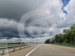 Empty highway with two lanes. Car traffic and road markings overlooking the gray clouds