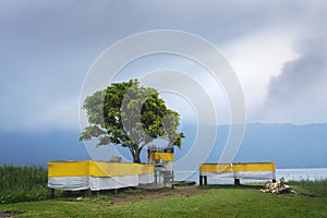 Empty Hindu Bali Temple on Lakeside After Religious Ceremonial Offering with Sunlight From Misty Morning Cloudy Sky Shinning on it