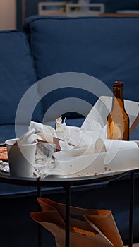 Empty home of depressed person with messy table with leftover on it