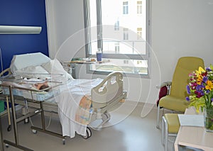 Empty hospital bed and newborn baby near the bed