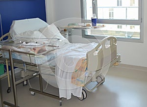 Empty hospital bed and newborn baby near the bed