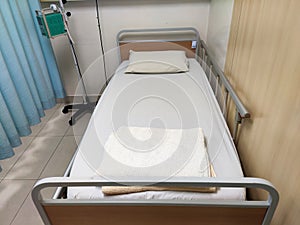 An empty hospital bed. It is in a state of readiness to accept patients.