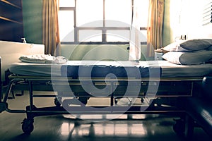 Empty  hospital bed with sunlight from the window,vintage tone