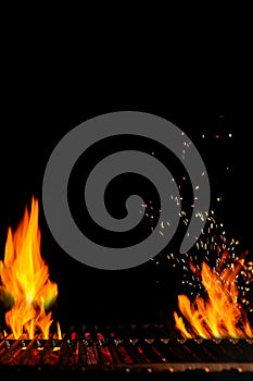 Empty hot barbecue BBQ grill with bright burning fire and sparks, smoldering coal on black background. Close up, copy