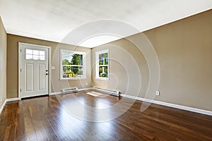 Empty house interior. Hardwood floor and beige walls.