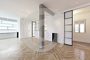 Empty house with a modern loft-style design with raw concrete beams and columns, metal-like stoneware floors and large black metal