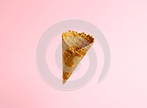 Empty ice cream waffle cup levitates on pink background