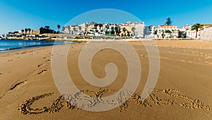 Empty idyllic sandy Praia do Ribeiro in Cascais, Portugal with the words Cascais written on sand photo