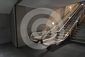 Empty illuminated escalator with a dirtproof grating at night