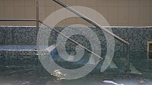 Empty indoor swimming pool with flares on water