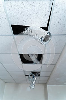 Empty industrial facility with grey wall. Internet cable hangs from the ceiling. Air conditioning tube. Closeup