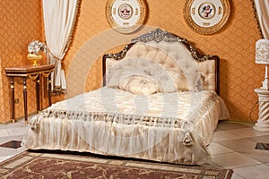 Empty interior bedroom background in warm colors decorated with classic luxury furniture