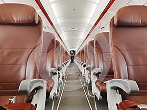 Empty interior cabin of an Airbus A320 Neo with red seats and trim. Many airlines face dire straits as they face a worldwide