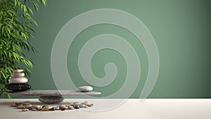 Empty interior design feng shui concept zen idea, white table or shelf with pebble balance and green bamboo, over green background