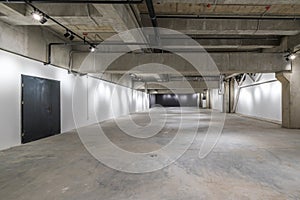 Empty interior of large concrete room as warehouse or hangar with spotlights