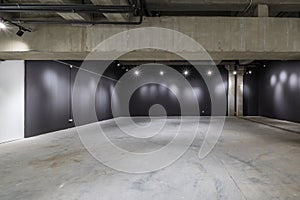 Empty interior of large concrete room as warehouse or hangar with spotlights