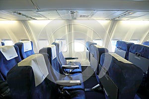 Empty interior of modern airplane with blue seats and no passangers.