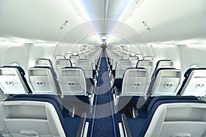Empty interior of modern airplane Boeing 737-8 Max with blue seats and no passangers.