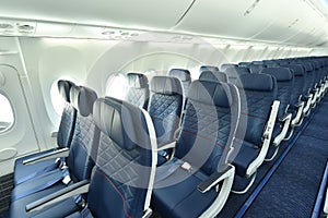 Empty interior of modern airplane Boeing 737-8 Max with blue seats and no passangers.