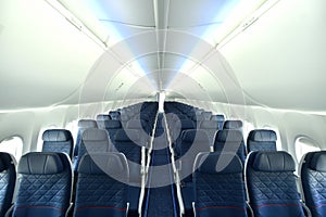 Empty interior of modern airplane Boeing 737-8 Max with blue seats and no passangers.
