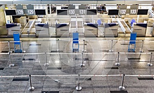 Empty international airport building, lack of passengers during the global crisis and diseases. Empty row check-in desks