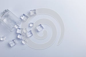 Empty inverted fallen glass with ice, on a white background