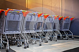 empty iron carts stacked in a row in the corner of a supermarket