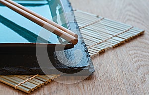 Empty Japanese sushi serving platter with chopsticks