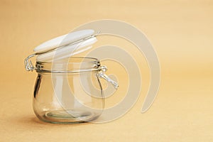 An empty jar with an open white lid
