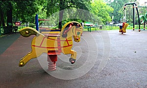 Empty kids playground in residential area, rocking horse in summer backyard