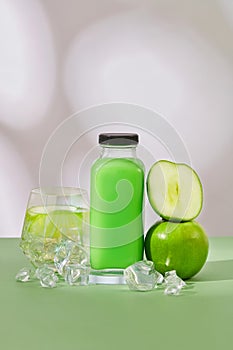 Empty label glass bottle of green apple juice decorated with some ices