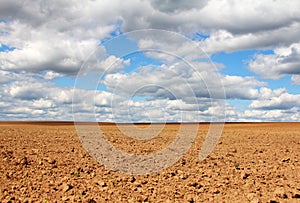 Empty land under cloudy sky