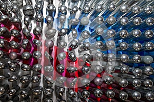 Empty laughing gas canisters reflecting colourful background. These metal cylinders contain nitrous oxide / laughing gas