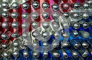 Empty laughing gas canisters reflecting colourful background. These metal cylinders contain nitrous oxide / laughing gas