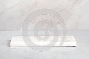 Empty light marble podium for product display on gray background