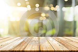 Empty light wood table top with blurred in coffee shop background