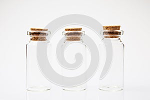 Empty little bottles with cork stopper on white background, close-up