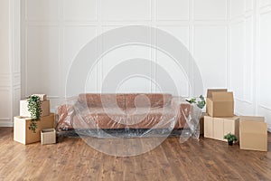 Empty living room with couch, stacks of boxes during relocation