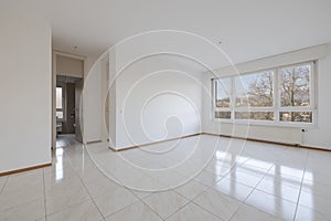 Empty living room with large bright window with a radiator underneath