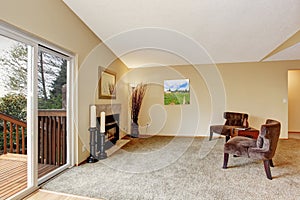 Empty living room in soft ivory with fireplace and walkout deck