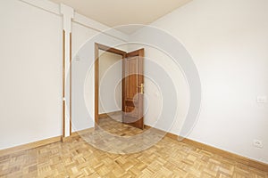 Empty living room with white painted walls, oak parquet floor