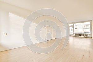 an empty living room with white walls and a window